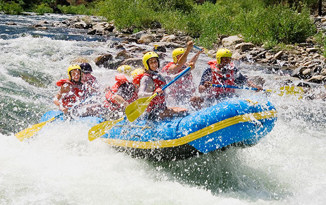 Group of young adults whitewater rafting