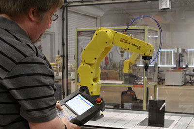 Instructor operating a robotic arm