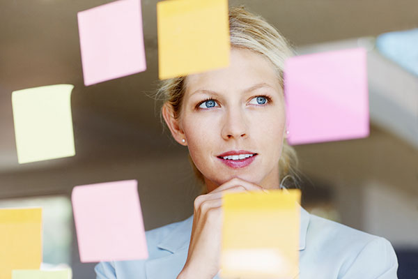 Business woman with sticky notes on glass window