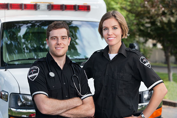 Paramedic team standing in front of an ambulance