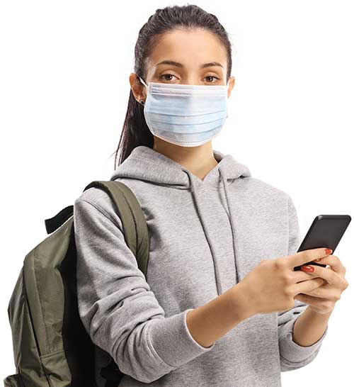 Female student wearing a protective mask while using a mobile phone