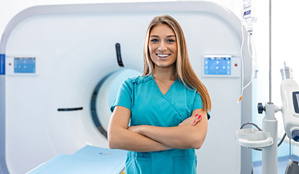 Computed Tomography Technologists in front of a CT scanner