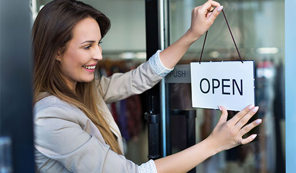 Person hanging an open sign