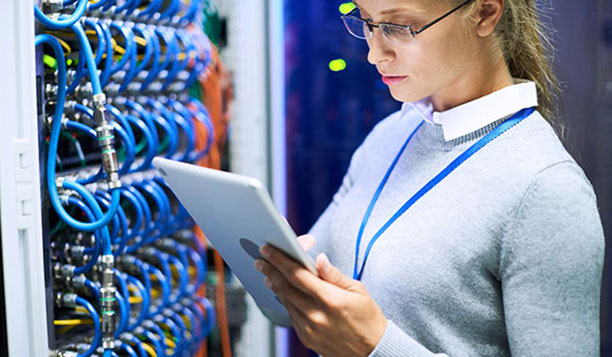 Person with a tablet in a server room