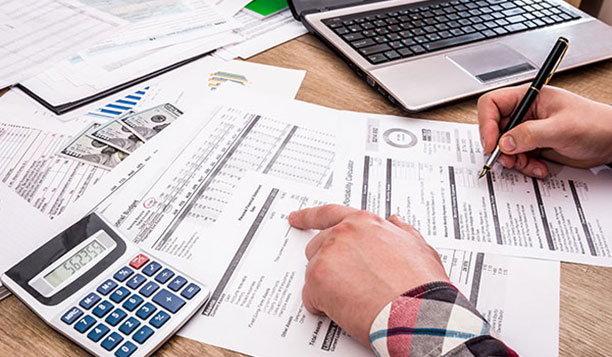 Person working on documents with a calculator