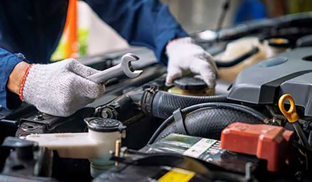 Person working on an engine with a wrench