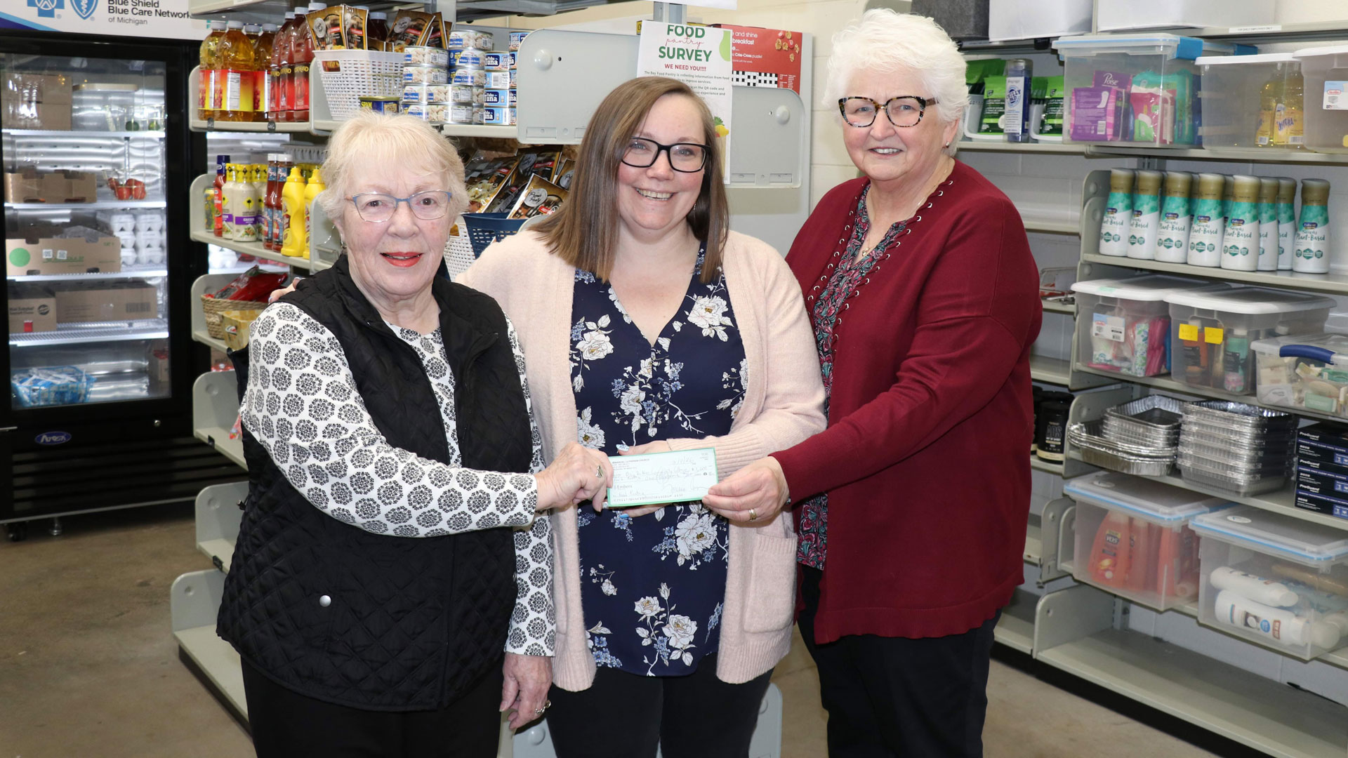 Barbara Denny and Linda McDonald present a $1,000 donation to Kari Meunier (at center) to support the Bay College Food Pantry.
