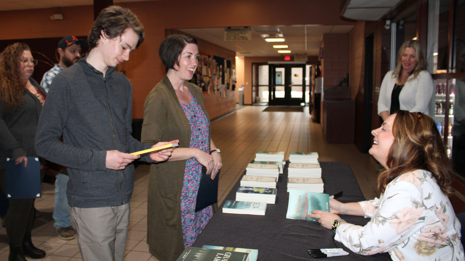 Mystery author J.L. Hyde signs books at the 2026 Trio 3.0 awards dinner.