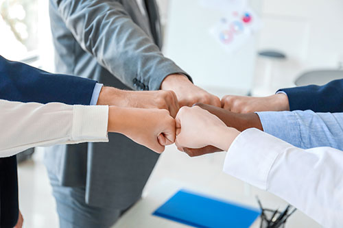 Group of people putting hands together