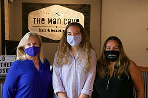 Three women wearing masks at the Man Cave