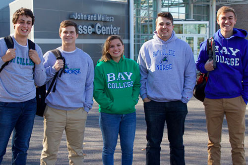 Group of smiling college students standing in a group outside