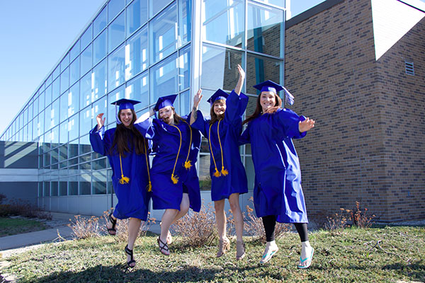 Group of Bay College graduates jumping in the air