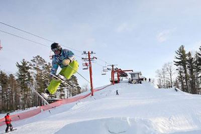 Skier flying off a jump on a ski hill