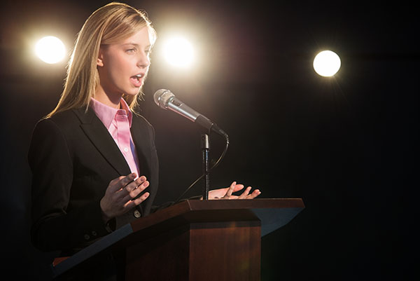 Woman speaks at podium with microphone