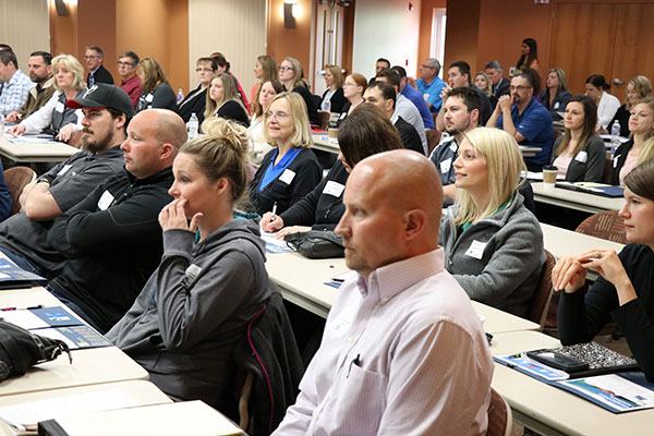 Professional attendees are pictured captivated listening to a workshop.