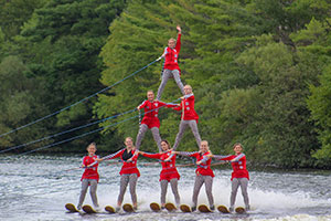 Waterskiers in a pyramid formation on the water