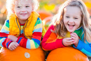Two kids in a pumpkin patch