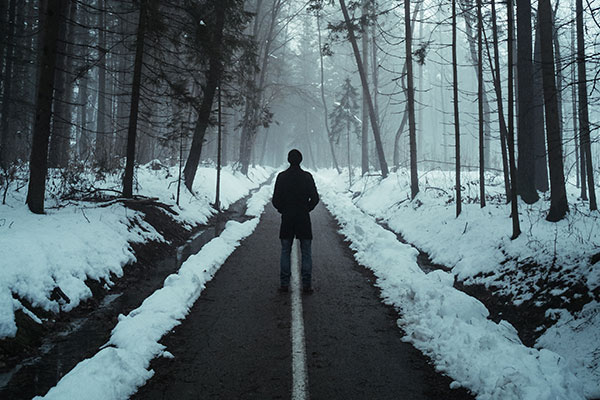 Man standing in the road in winter.