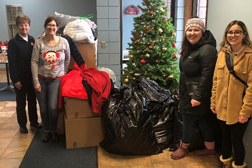 Captain Kim Winters and Jamie Ray, case manager, of the Salvation Army receive coat donations.