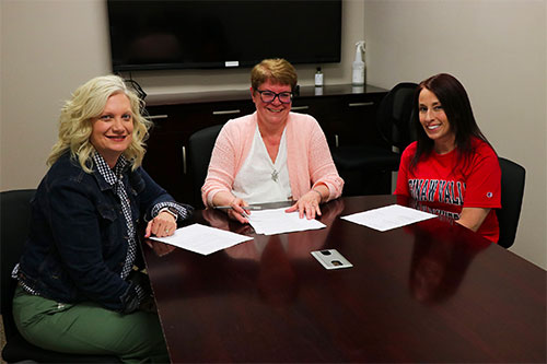 Three women sitting at a conference table